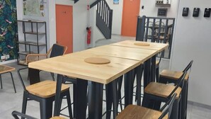 A conference room with a long table and chairs, a staircase, and a fire extinguisher on the wall. - Grande Maison de ville design avec parking gratuit (Gannat)