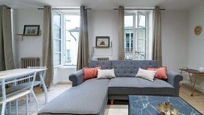 Una sala moderna con un sofá seccional gris, una mesita y una mesa de centro.