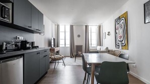 Une cuisine moderne avec des meubles de couleur sombre, un four à micro-ondes encastré et un lave-vaisselle en acier inoxydable.
