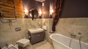 A bathroom with a bathtub, a bidet, a sink, and a mirror. - Ex. Best Western Hotel Zubrowka (Bialowieza)