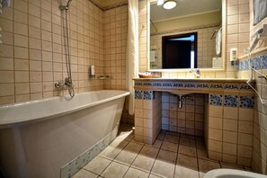 Une salle de bain avec une baignoire, un lavabo et un miroir.