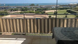 A balcony with a view of a parking lot and the ocean. - Vias Plage - Apt. vue mer 4 Pers. Climatisé Avec Piscine - REF V0823 (Vias)