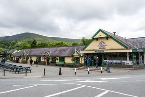 Une station dotée d’une boutique et de bancs, entourée de verdure et de collines.