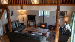 Una sala de estar acogedora con chimenea, muebles de madera y un televisor.