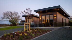 Ein modernes, zweistöckiges Gebäude mit minimalistischem Design, große Glasfenster und ein gepflegter Gartenbereich.