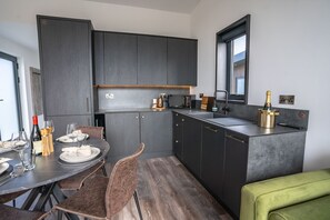 Een koelkast, een magnetron, een vaatwasser, eettafels