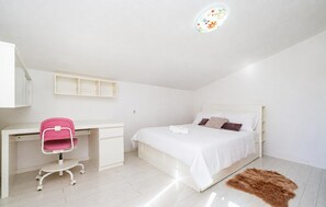 Ein Schlafzimmer mit einem Bett, einem Schreibtisch und einem Stuhl.