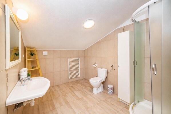Un baño con lavamanos, inodoro y ducha.