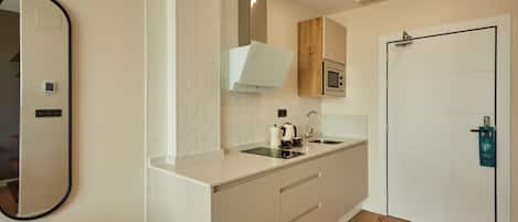 Una cocina moderna con microondas, pileta y alacenas.