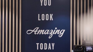 En receptionsdisk med et skilt, der siger 'YOU LOOK AMAZING TODAY', og en kaffemaskine.