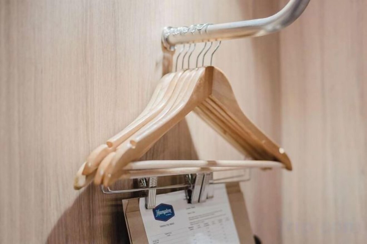 A wooden hanger with a tag attached to it.