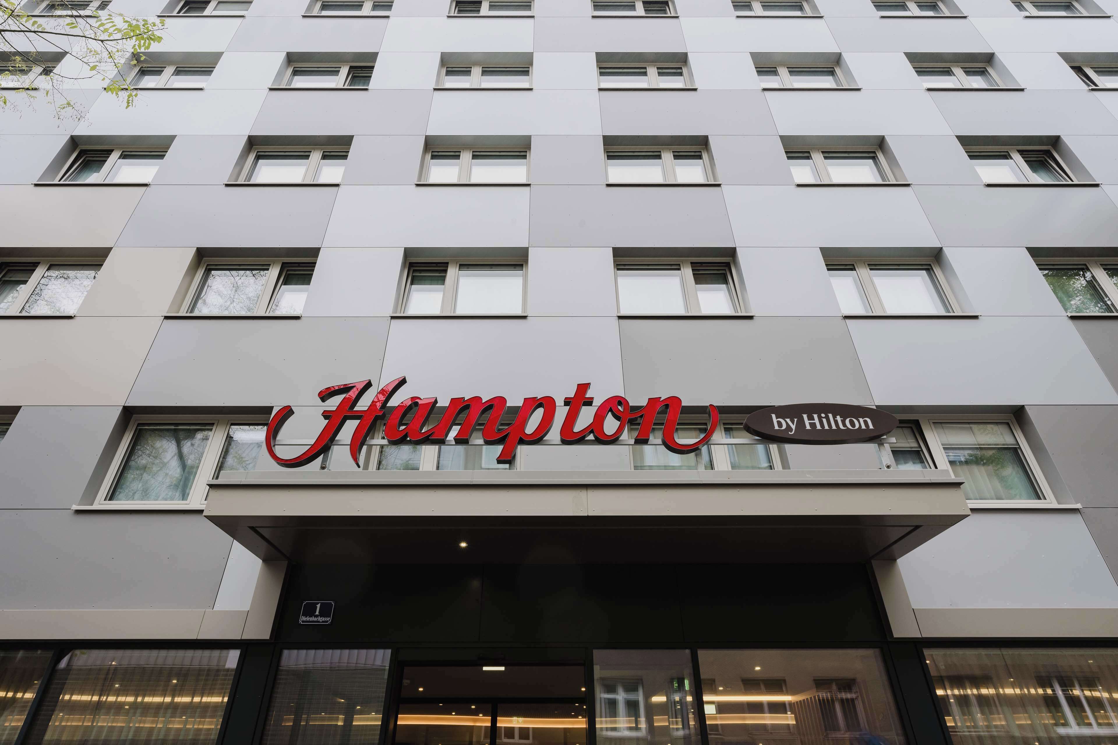 Eine Hotelansicht mit einem gut sichtbaren Schild von Hampton by Hilton.
