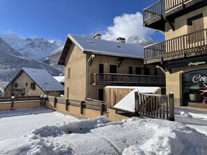 Un edificio coperto di neve con un balcone e un cartello con su scritto 'Colbure'.