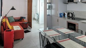 A modern kitchen with a dining area, featuring a large table, chairs, and a hanging light fixture. - Madrid Mola ! (Madrid)