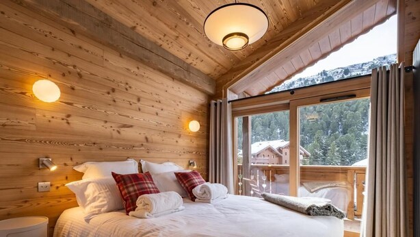 A wooden cabin bedroom with a large bed, two bedside tables, and a window with curtains. - 2nd floor, view mountain, balcony, fireplace or stove, parking, tv, ski locker, 69m² (Méribel - Les Allues)