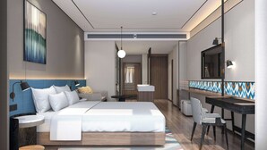 A modern hotel room with a large bed, bedside tables, a desk, and a mirror. - Hilton Garden Inn Ili Yining (Yining)