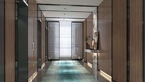 A modern hallway with a patterned carpet, wooden paneling, and a large mirror on the wall. - Hilton Garden Inn Ili Yining (Yining)