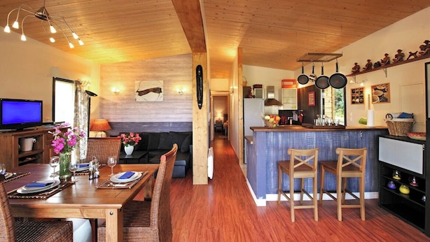 A cozy interior with a dining area, a kitchen, and a living space. - Ecolodge calme & piscine privée (Roquetaillade-et-Conilhac)