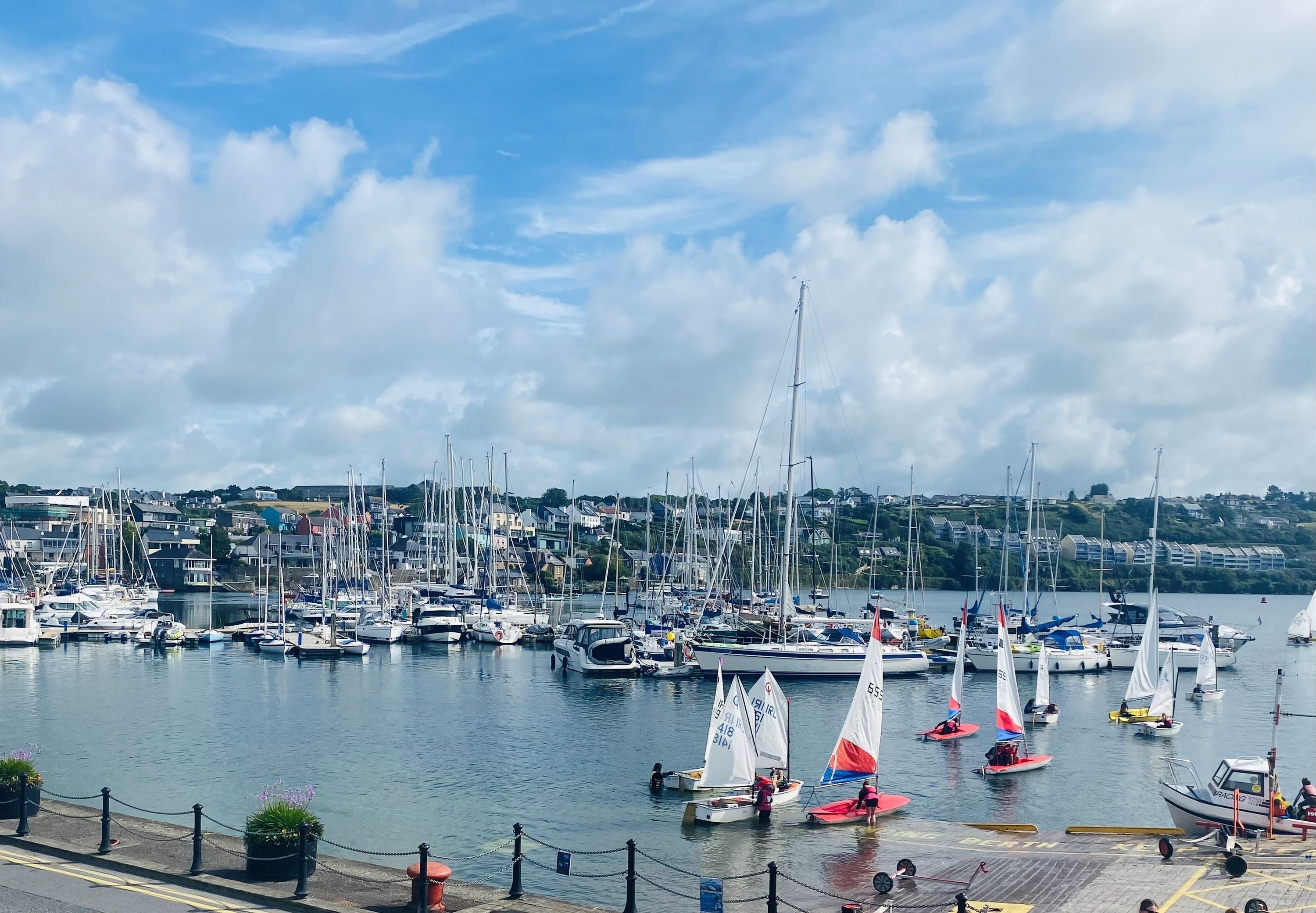 A marina with multiple sailboats and yachts docked.
