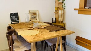 Ein Holztisch mit einer gewebten Tischmatte, umgeben von Stühlen.