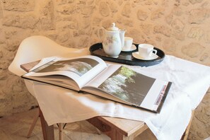 A table with a book, a tray with a teapot and cups, and a chair. - Borgo San Valentino (Arrone)