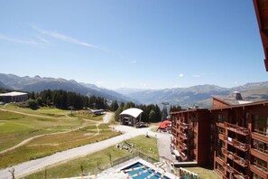 Un hotel con piscina, telesilla y vistas a la montaña.