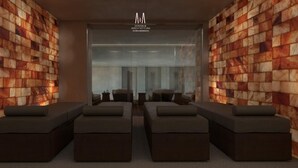 A modern interior with a wooden wall design, a central seating area with sofas, and a visible logo for 'Design & Architecture Studio Associato'. - Hotel Partner & Spa (Vlorë)