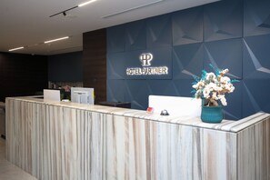 A hotel reception desk with a marble counter, a reception area, and a wall-mounted sign that reads "HOTEL PARTNER". - Hotel Partner & Spa (Vlorë)