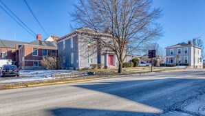 A street view with houses, a tree, and a road with visible cracks.