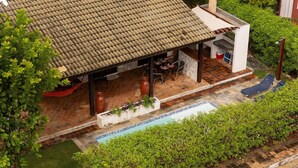 A covered patio area with a pool, surrounded by greenery and a tiled roof. - Casa Pipa Natureza Piscina Privativa 089 (Tibau do Sul)