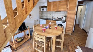 A compact kitchen with wooden cabinets, a microwave, and a sink. - Wifi, 1st floor, balcony, tv, ski locker, 34m², Serre Chevalier (Le Monêtier-les-Bains)