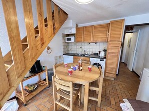 A compact kitchen with wooden cabinets, a microwave, and a sink.