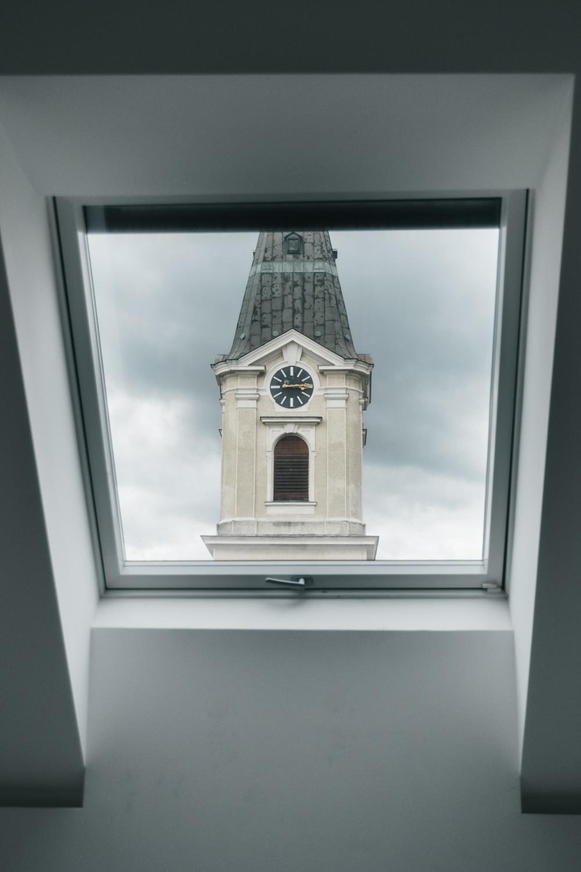 A skylight with a view of a clock tower.