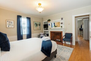 Relax in this inviting space with a large bed, brick fireplace, and comfortable seating area.