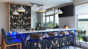 Un moderno espacio de bar con una estantería para vinos, taburetes y lámparas colgantes.