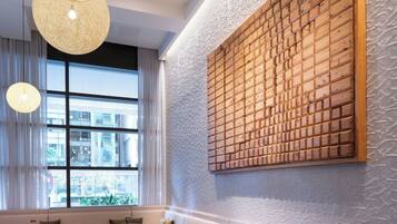 A modern interior with round tables, cushioned seating, and large hanging light fixtures.