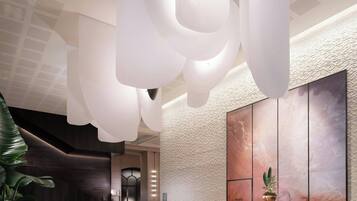 A modern lobby with a reception desk, seating area, and a large abstract painting on the wall.