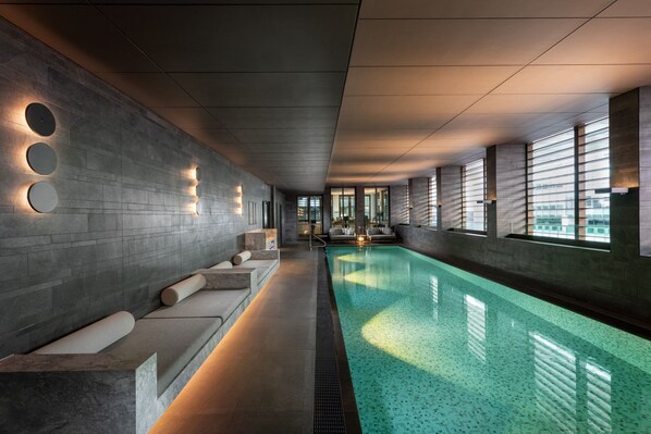 Una piscina techada, sillones reclinables de piscina