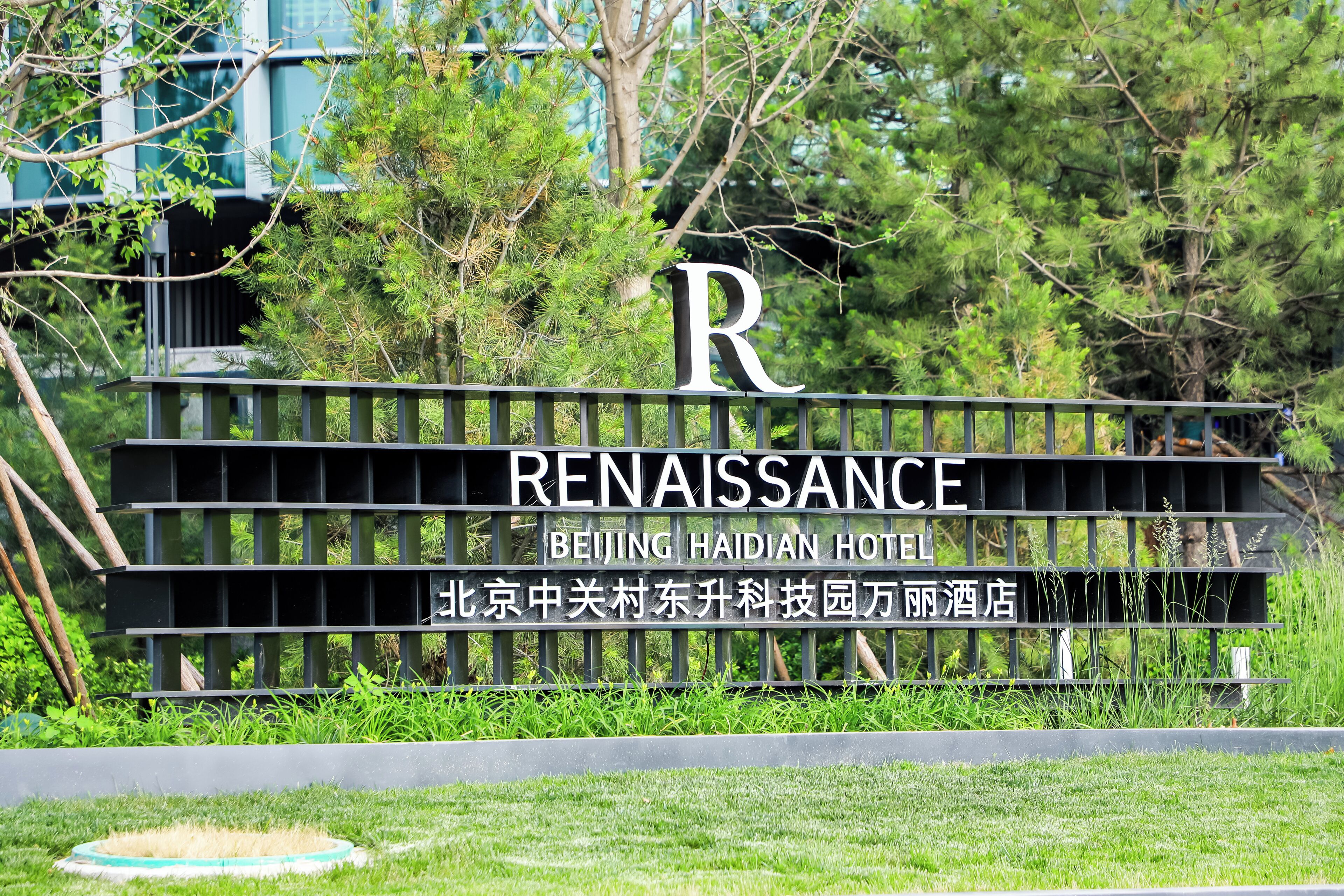 Een bord voor het Renaissance Beijing Haidian Hotel, met een grote 'R' en de hotelnaam in zowel Engels als Chinees.
