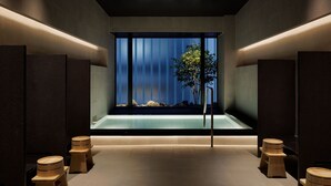 Un área de spa moderna con un ventanal grande, taburetes de madera y un diseño minimalista.