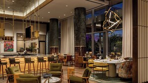 A modern dining area with high ceilings, large windows, and contemporary furniture. - HALL Park Hotel, Autograph Collection (Frisco)