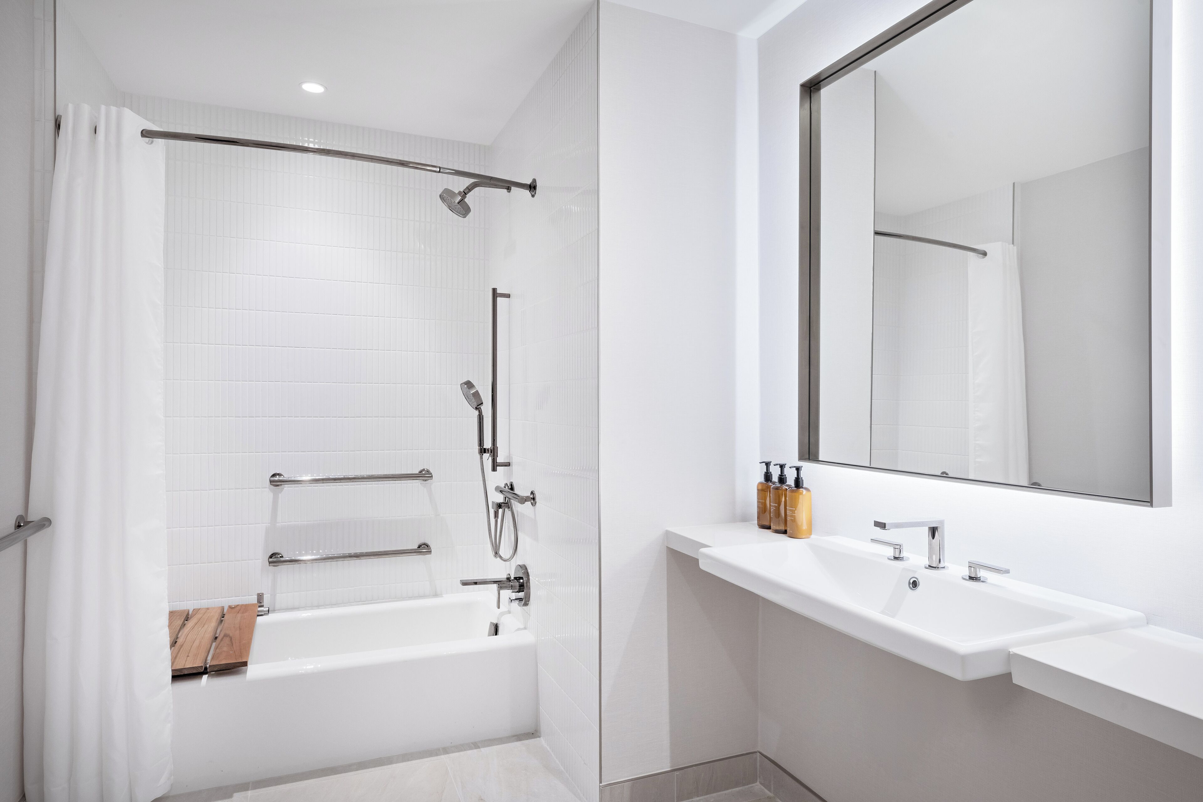 A modern bathroom with a bathtub, shower, and dual sinks.
