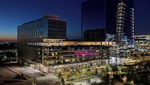 A modern hotel with multiple floors, a rooftop terrace, and a glass facade. - HALL Park Hotel, Autograph Collection (Frisco)