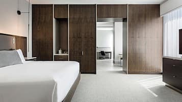 Ein modernes Hotelzimmer mit einem großen Bett, einem Schreibtisch und einem Kleiderschrank.