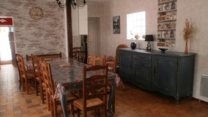 Un comedor con una mesa y sillas de madera, un aparador azul y un reloj en la pared.