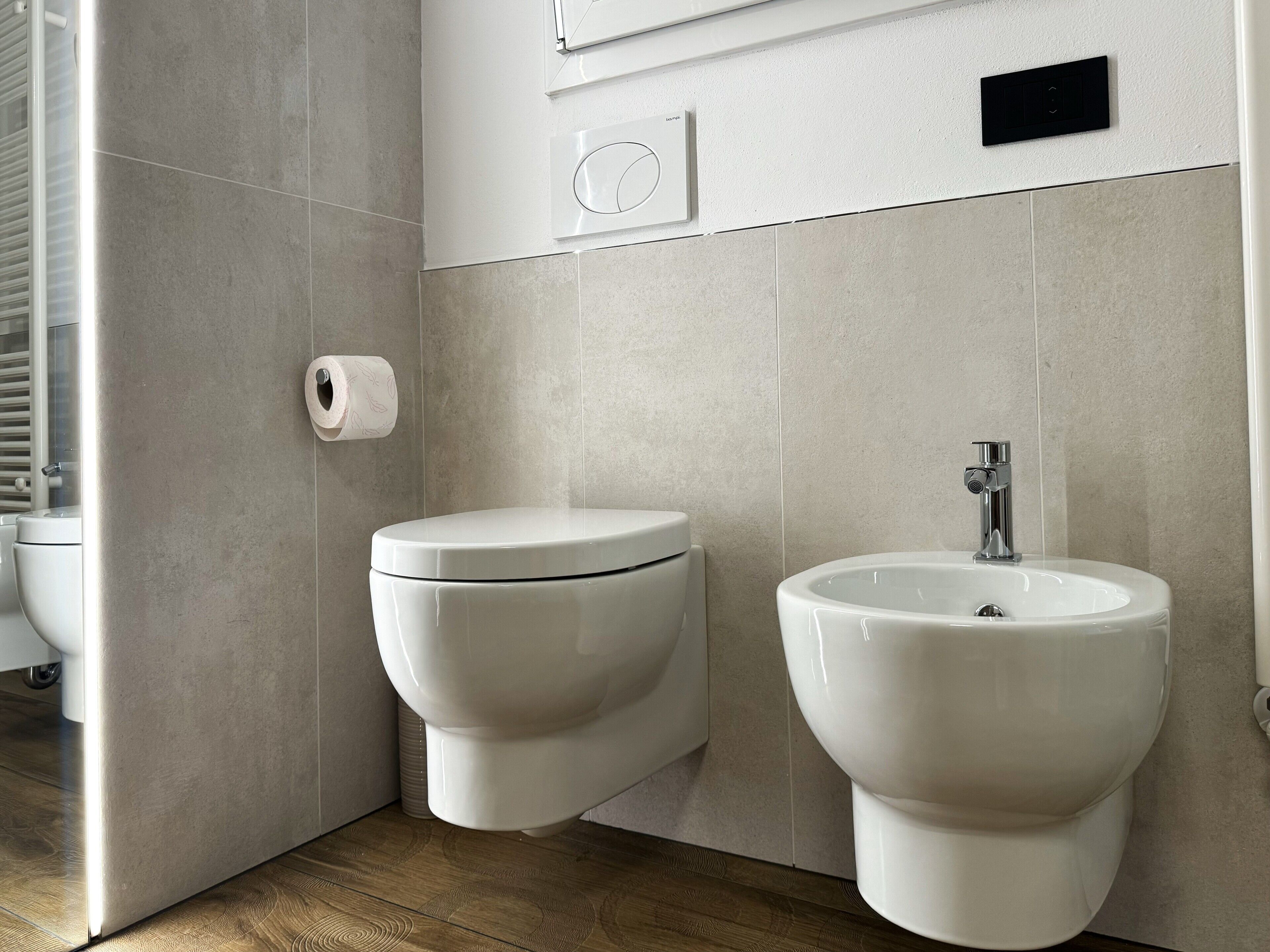A modern bathroom with a toilet, bidet, and sink.