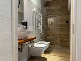 Habitación Deluxe con 1 cama doble o 2 individuales | Baño | Ducha, cabezal de ducha tipo lluvia, secador de pelo y albornoces