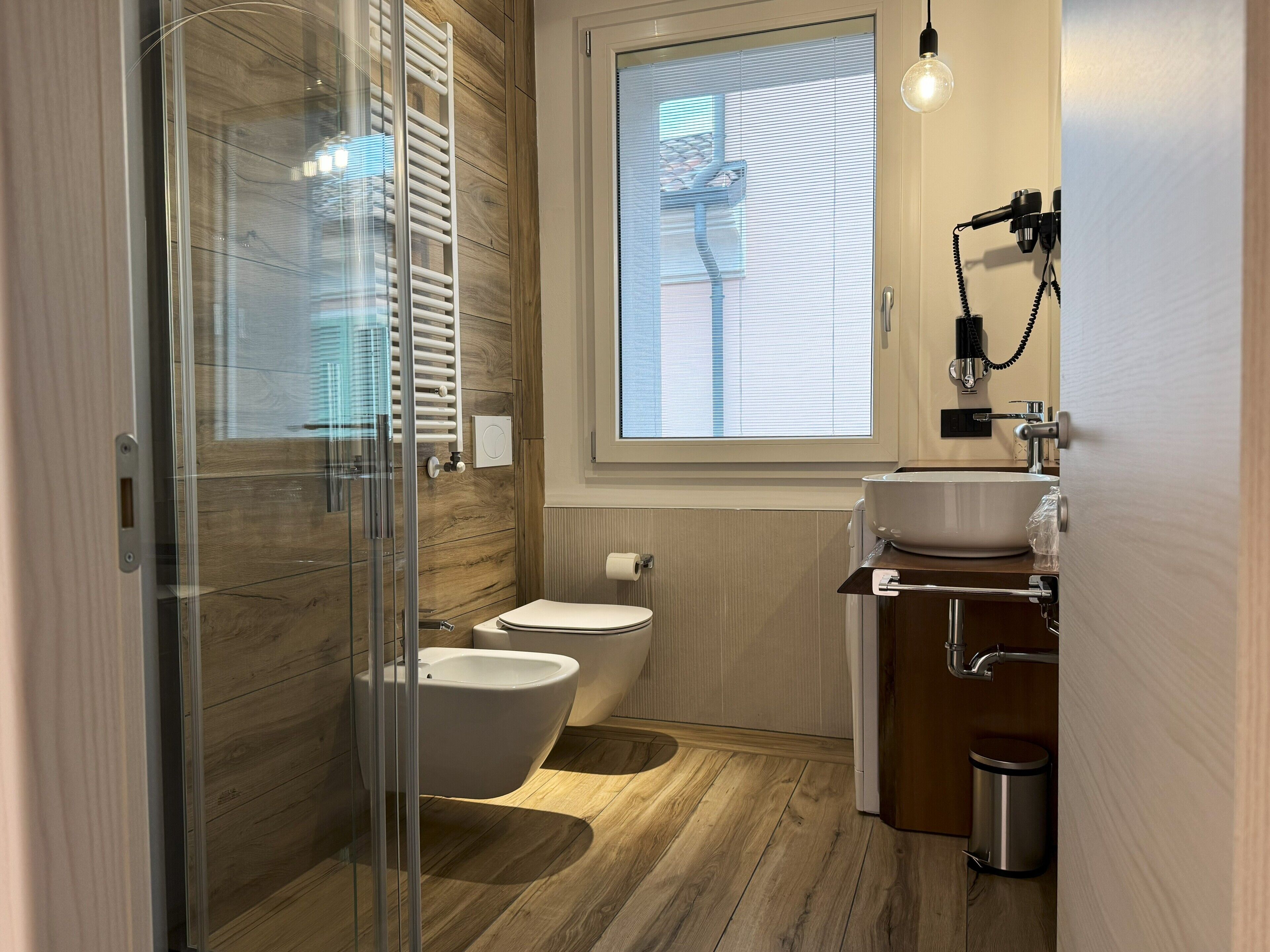 Un bagno moderno con box doccia in vetro, un water e un bidet.