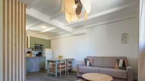 A modern living space with a kitchen, dining area, and seating area. - Cottage with AC and terrace n°10 (La Roque-sur-Pernes)