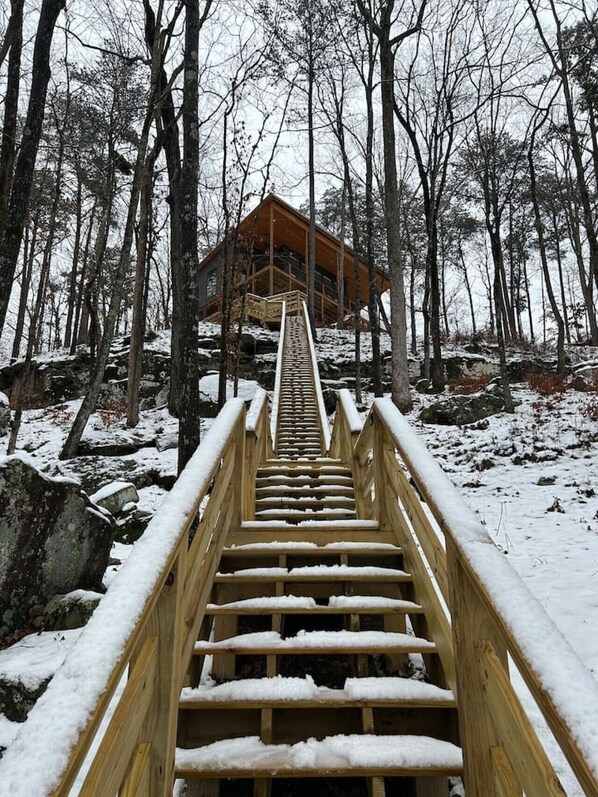 Escape to a secluded cabin nestled among the trees, with a balcony offering a serene forest view.